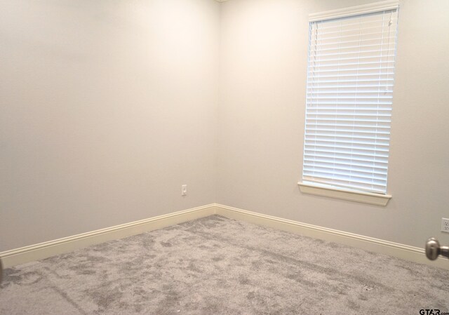 unfurnished room with baseboards and carpet