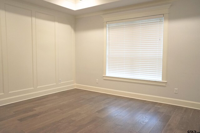 unfurnished room featuring baseboards and dark wood-style flooring