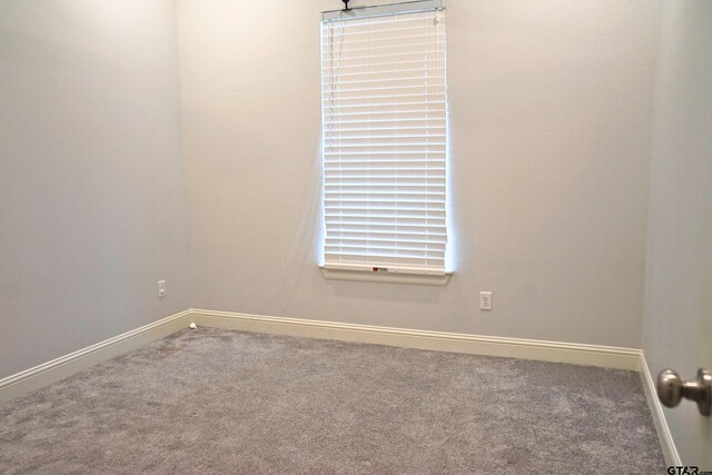 empty room featuring carpet flooring and baseboards
