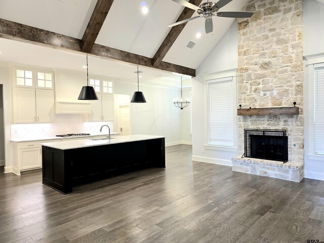 kitchen featuring open floor plan, light countertops, a sink, and a ceiling fan