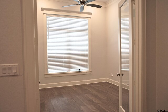 empty room with dark wood finished floors, baseboards, and ceiling fan