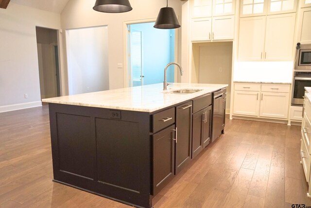 kitchen with white cabinets, a sink, appliances with stainless steel finishes, and wood finished floors