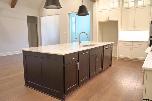kitchen with white cabinetry, stainless steel appliances, a center island with sink, a sink, and wood finished floors