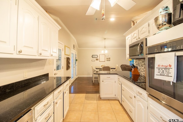 kitchen featuring appliances with stainless steel finishes, pendant lighting, white cabinetry, and light tile patterned floors