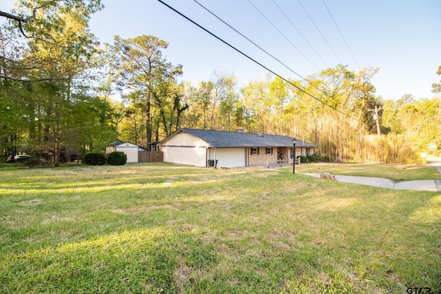 exterior space featuring a storage shed, brick siding, an outbuilding, and a front yard