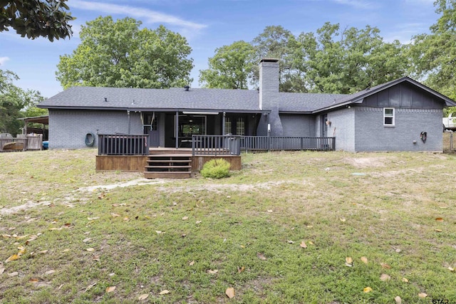 14553 Stone Creek Dr, Tyler, TX 75709 - rear view of house featuring a wooden deck, a chimney, brick siding, and a lawn