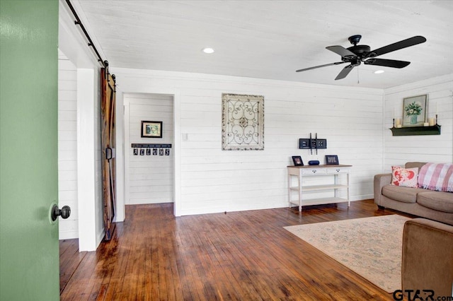 13926 State Highway 64e, Tyler, TX 75707 - living room with a barn door, dark wood-style floors, a ceiling fan, wooden walls, and recessed lighting