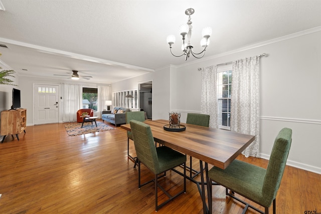 dining room featuring hardwood / wood-style flooring, ornamental molding, and ceiling fan with notable chandelier