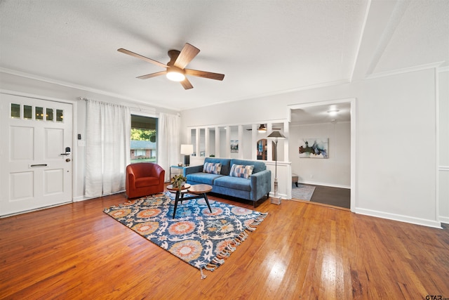 living room featuring ceiling fan, beamed ceiling, wood-type flooring, and a textured ceiling