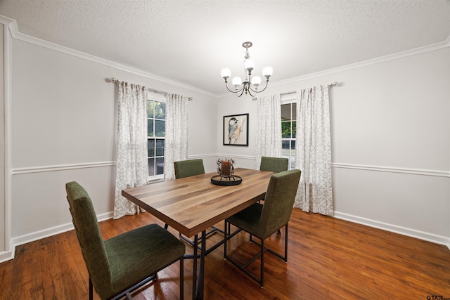 dining room with a textured ceiling, ornamental molding, hardwood / wood-style flooring, and a chandelier