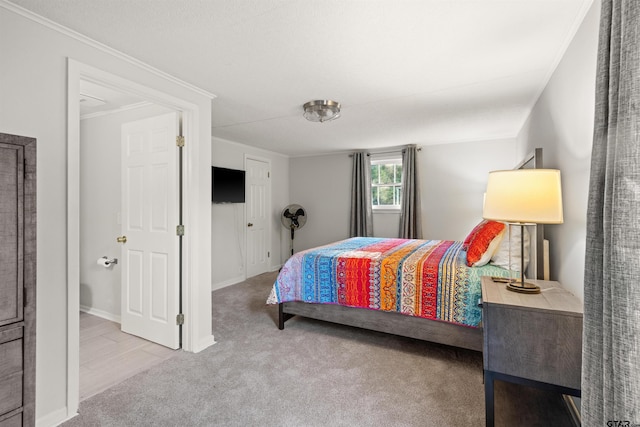 bedroom with ornamental molding and carpet floors