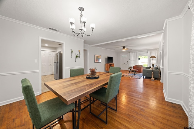 dining room featuring wood-type flooring, crown molding, and ceiling fan with notable chandelier