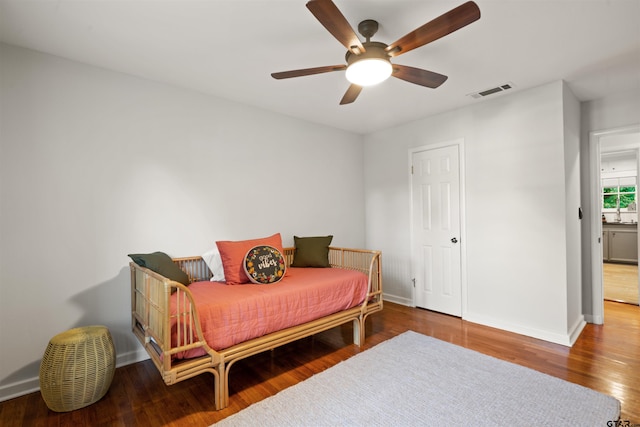 bedroom with dark hardwood / wood-style flooring and ceiling fan