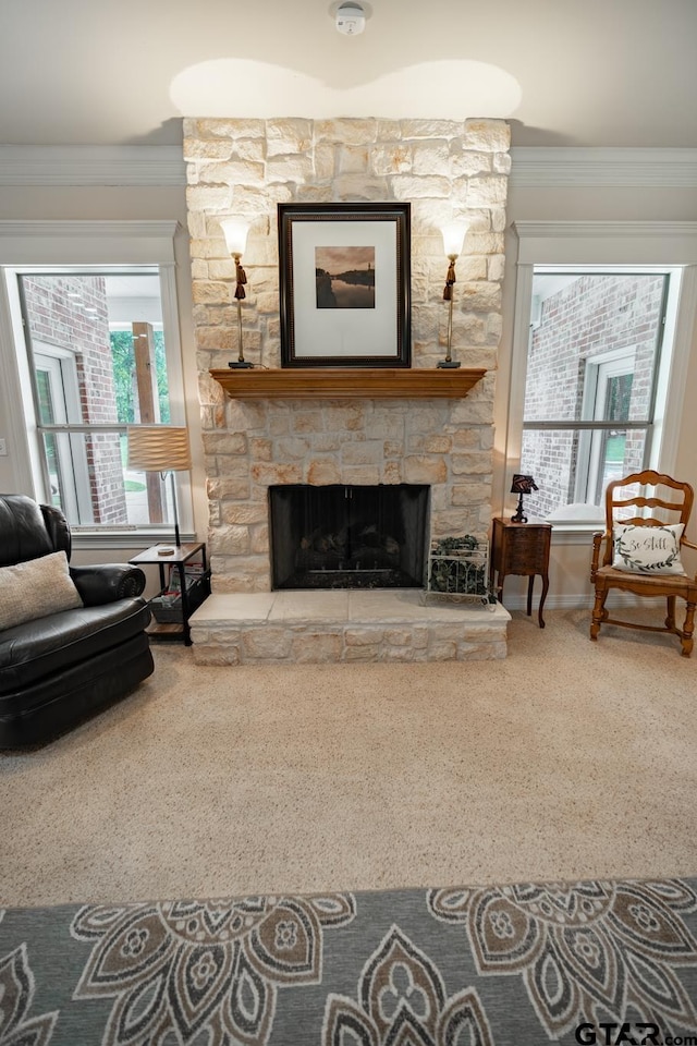 living room featuring a stone fireplace, carpet flooring, and ornamental molding