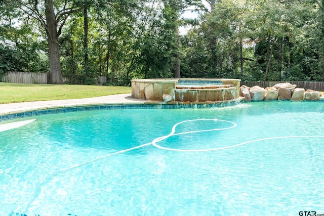 view of pool with a yard and an in ground hot tub