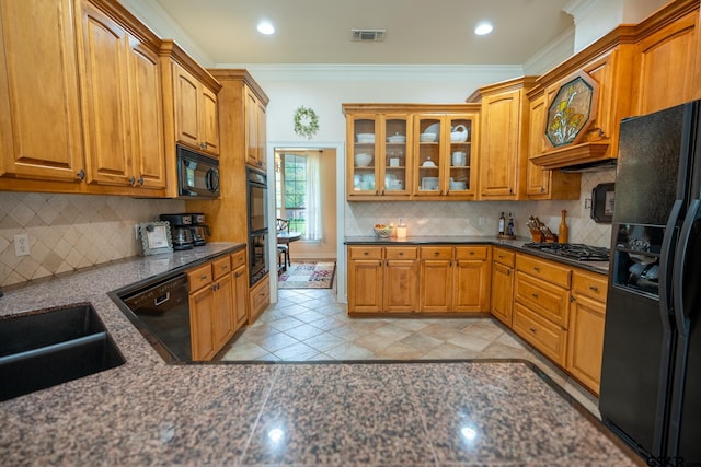 kitchen with black appliances, tasteful backsplash, crown molding, and dark stone countertops