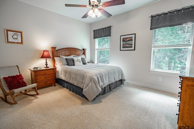 bedroom with ceiling fan, multiple windows, and carpet floors