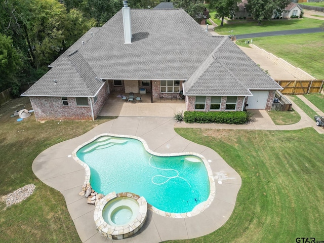 view of pool with a lawn, a patio, and an in ground hot tub