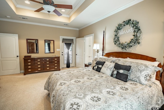 carpeted bedroom with ornamental molding, ceiling fan, and a raised ceiling