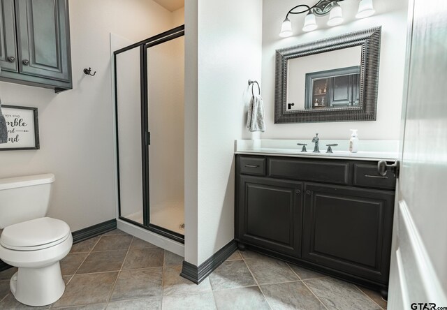 bathroom featuring vanity, tile patterned floors, toilet, and a shower with shower door