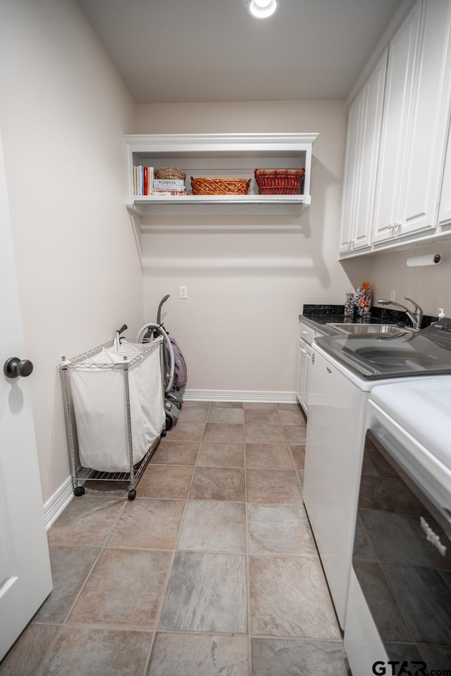 laundry area featuring cabinets, sink, and washing machine and clothes dryer