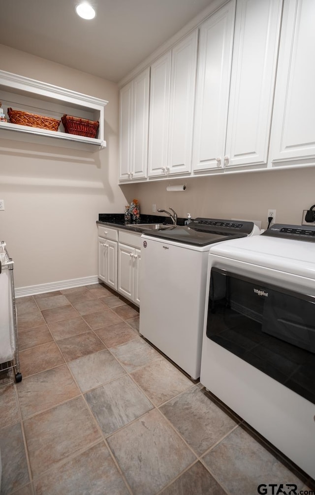 laundry area with cabinets, washing machine and dryer, and sink