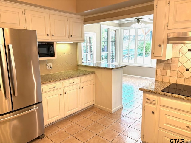 kitchen featuring decorative backsplash, light tile patterned floors, black appliances, and light stone counters