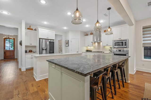 763 Hampton Hill Hill, Tyler, TX 75703 - kitchen with appliances with stainless steel finishes, a large island with sink, light wood-style flooring, backsplash, and recessed lighting