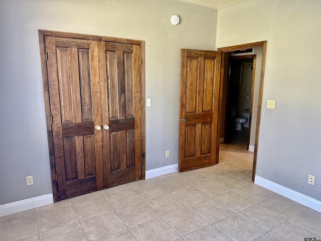 unfurnished bedroom featuring light tile patterned floors and baseboards