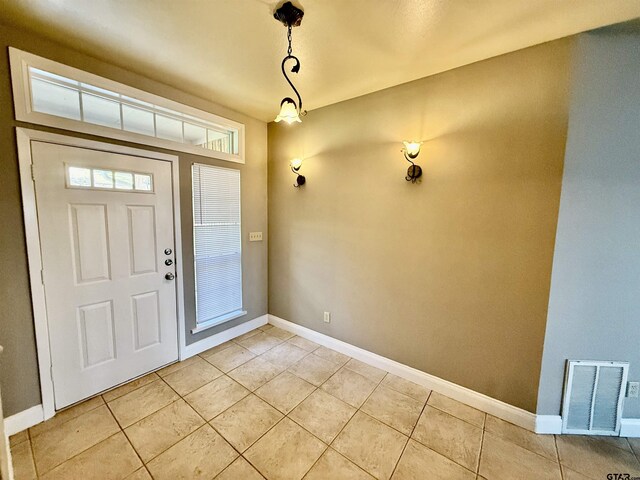 entrance foyer featuring light tile patterned floors, visible vents, and baseboards