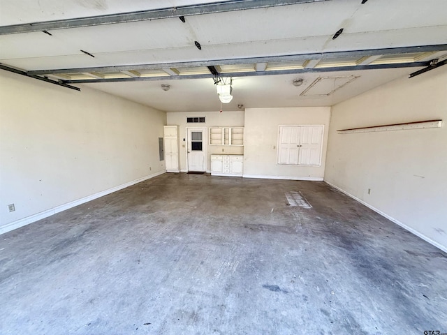 garage with visible vents, a garage door opener, and baseboards