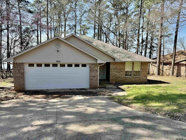 single story home with concrete driveway, an attached garage, brick siding, and a front lawn