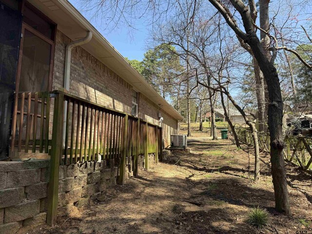 view of side of property with brick siding and central air condition unit