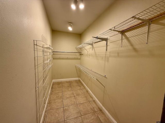 walk in closet with light tile patterned floors