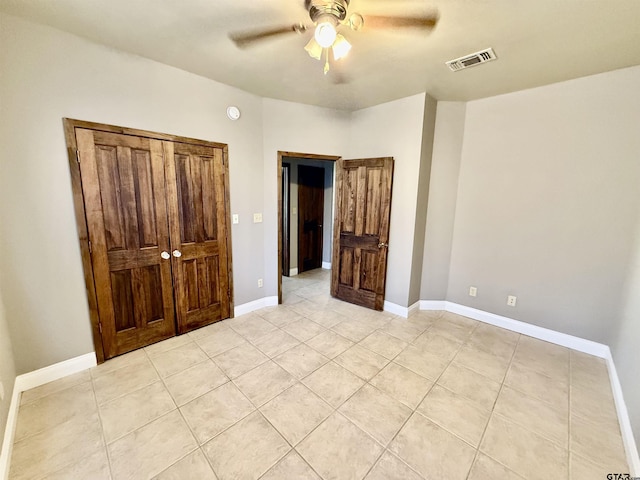 unfurnished bedroom with light tile patterned floors, visible vents, ceiling fan, and baseboards