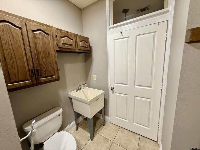 bathroom featuring tile patterned flooring, toilet, and baseboards