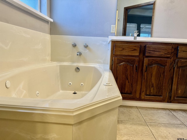 full bathroom featuring tile patterned floors, a jetted tub, and vanity