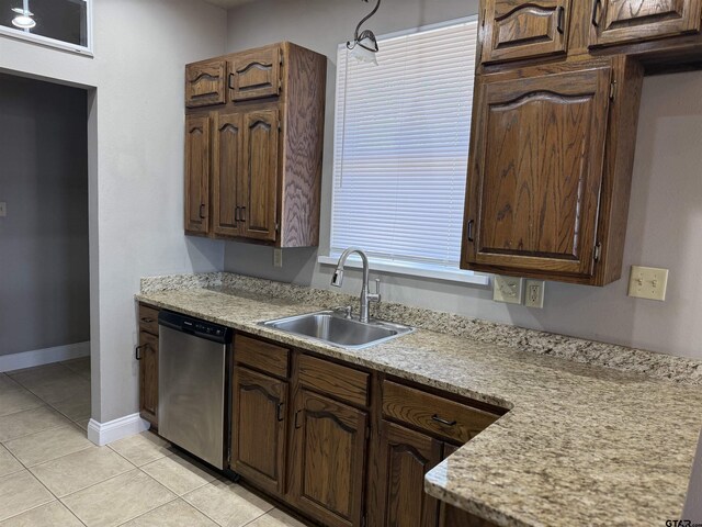 kitchen featuring dishwasher, light countertops, and a sink