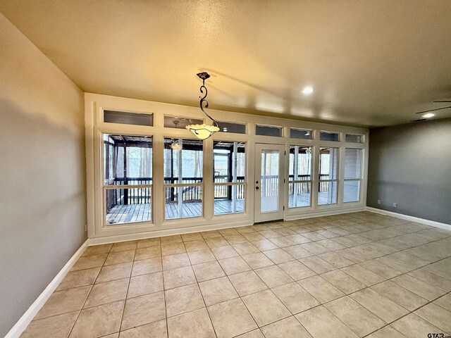 unfurnished room featuring light tile patterned floors and baseboards