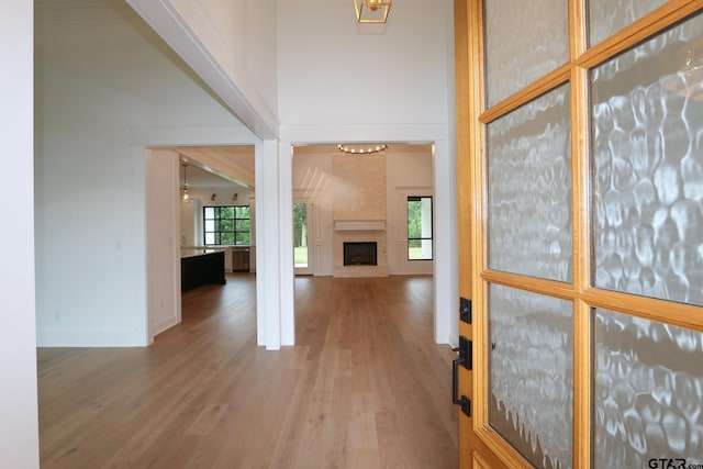 16511 Cooper Way, Tyler, TX 75703 - unfurnished living room featuring wood finished floors, a high ceiling, a fireplace, baseboards, and a chandelier