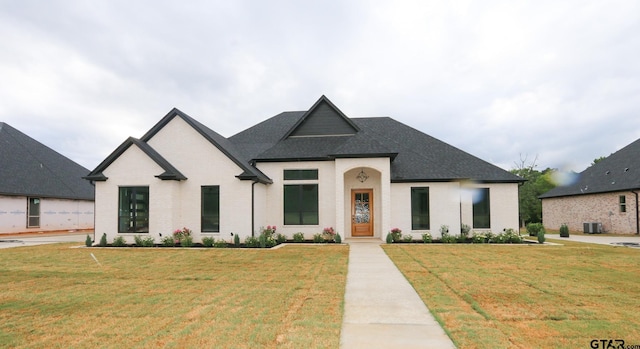 16511 Cooper Way, Tyler, TX 75703 - french country home featuring brick siding, a front yard, central AC unit, and a shingled roof