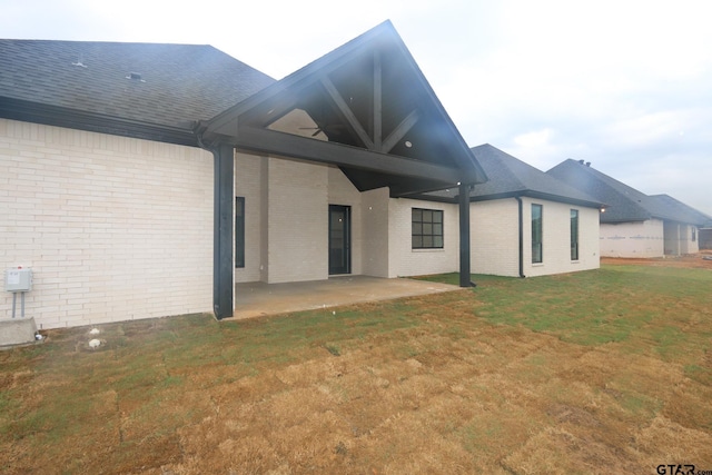 16511 Cooper Way, Tyler, TX 75703 - rear view of house with brick siding, a patio area, a lawn, and roof with shingles