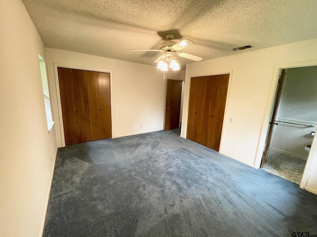 114 Briar Ln, Crockett, TX 75835 - unfurnished bedroom with carpet flooring, multiple closets, a textured ceiling, and a ceiling fan