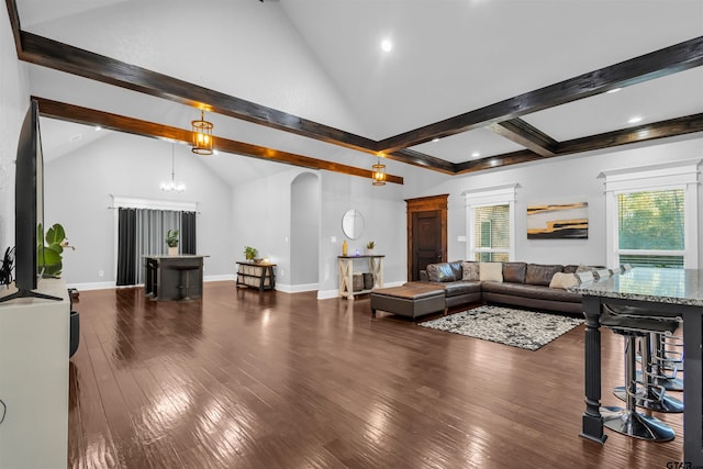 living room featuring dark hardwood / wood-style flooring, lofted ceiling with beams, and a chandelier