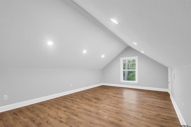 additional living space with lofted ceiling and hardwood / wood-style floors