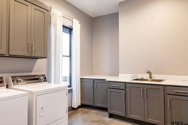 laundry room featuring cabinet space, a sink, and washer and clothes dryer