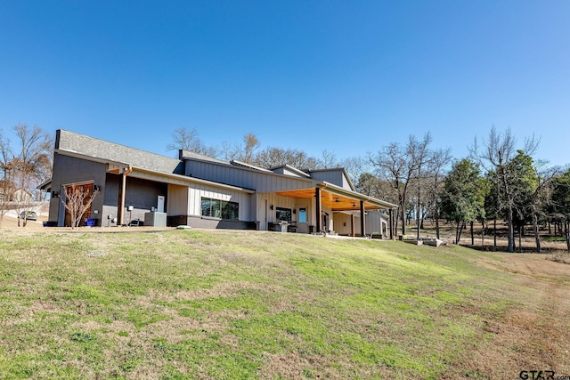 rear view of property with central AC and a lawn