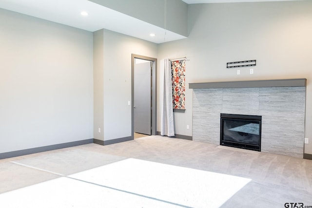 unfurnished living room with recessed lighting, carpet, a fireplace, and baseboards