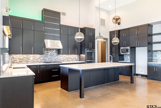 kitchen with visible vents, decorative backsplash, range hood, stainless steel appliances, and a sink