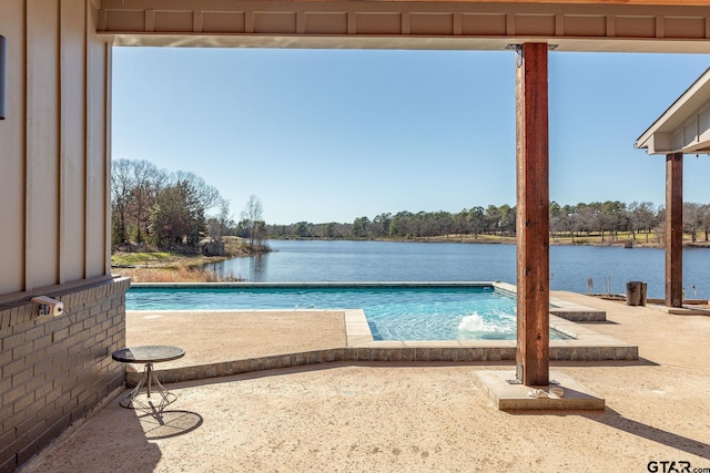 outdoor pool featuring a water view and a patio